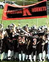 Football players under an orange and black K banner