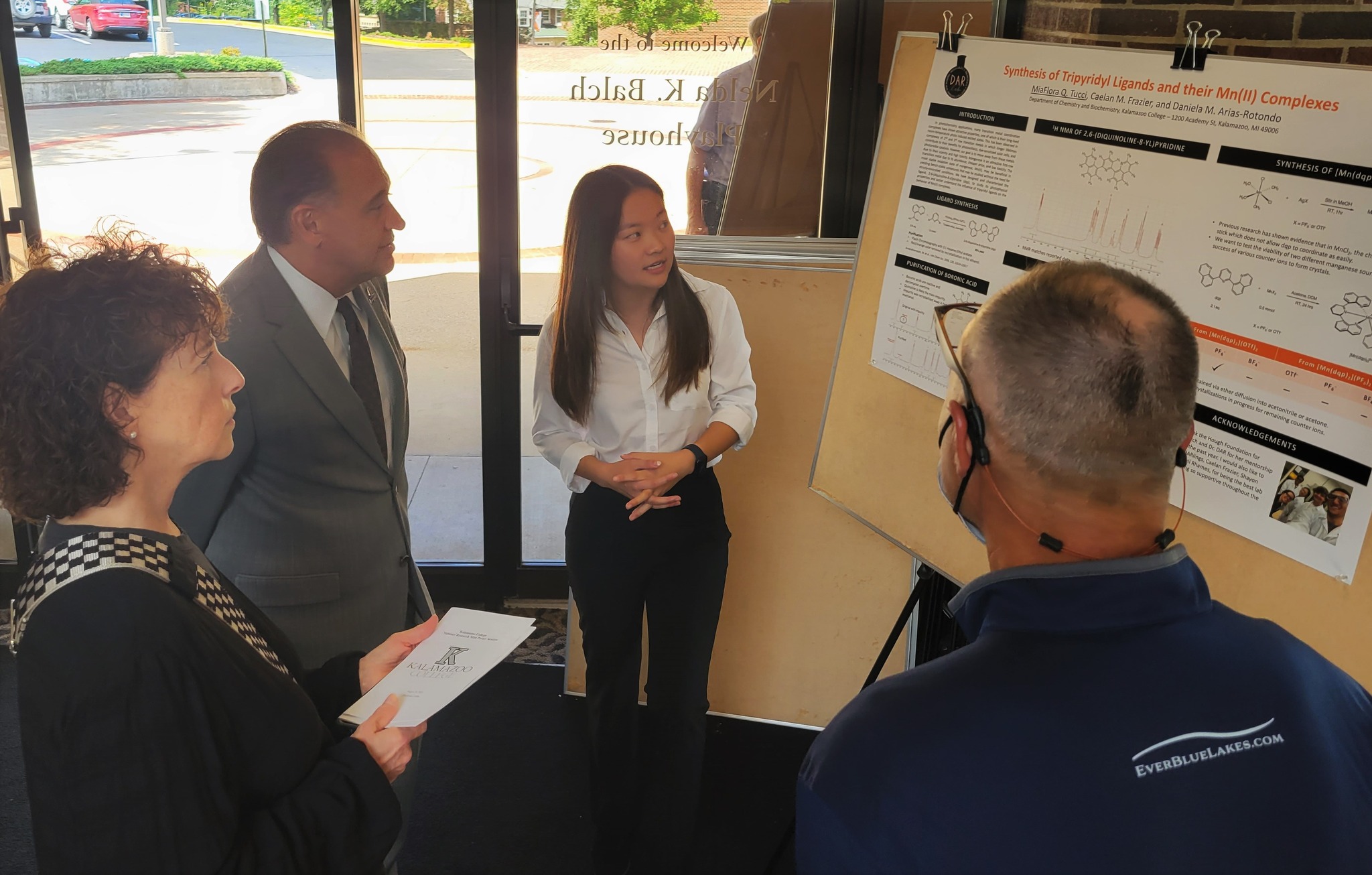 Student presenting her research to president Gonzalez