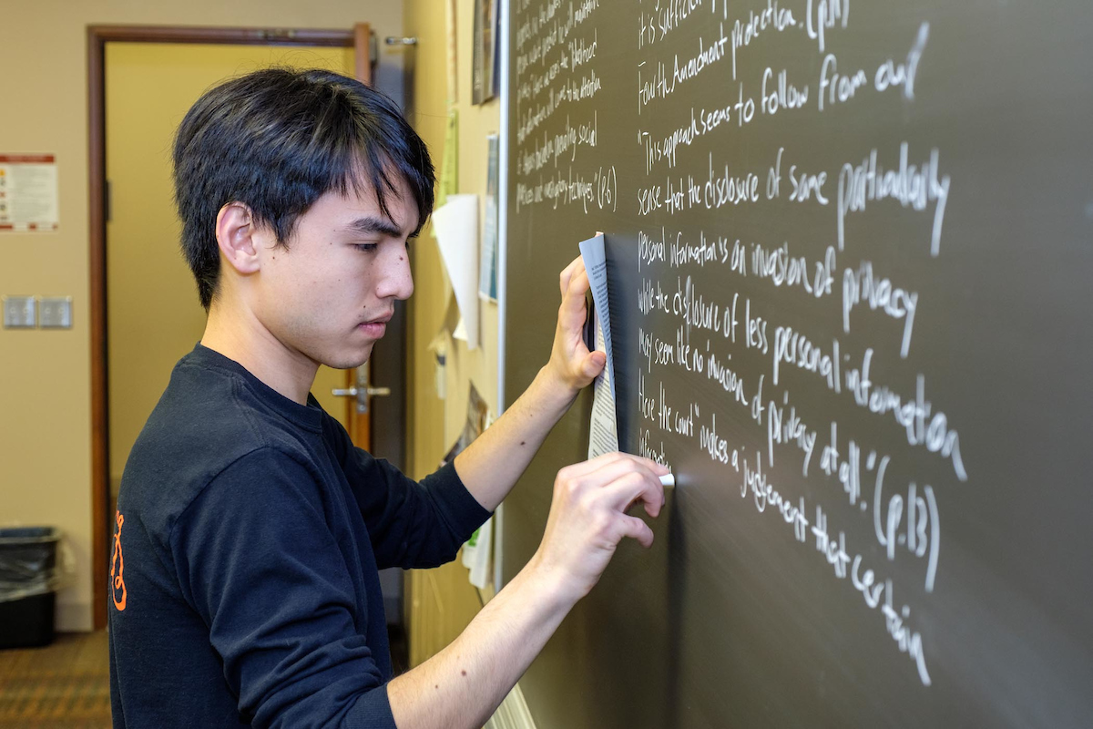 A student writing on a chalk board