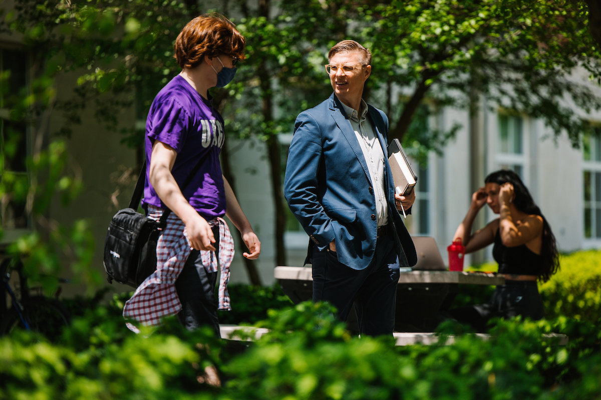 Religion professor Taylor Petrey speaking with a student