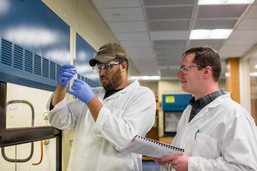 A student and professor in a chemistry lab