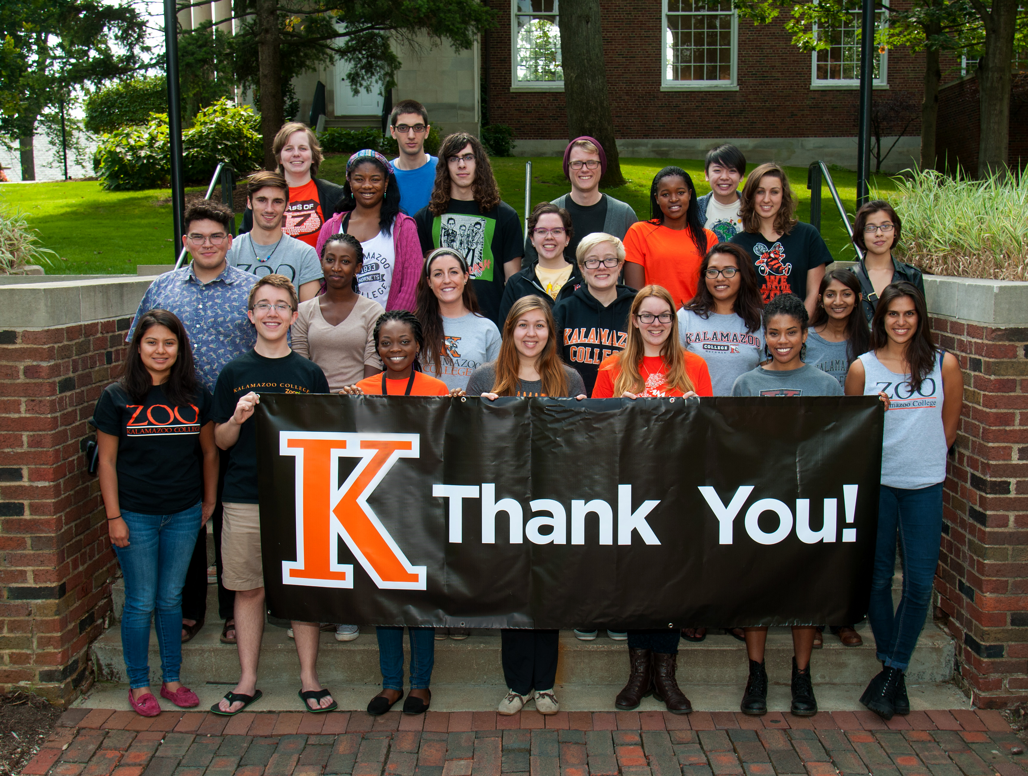 Kalamazoo College student phonathon callers holding a Thank You banner.