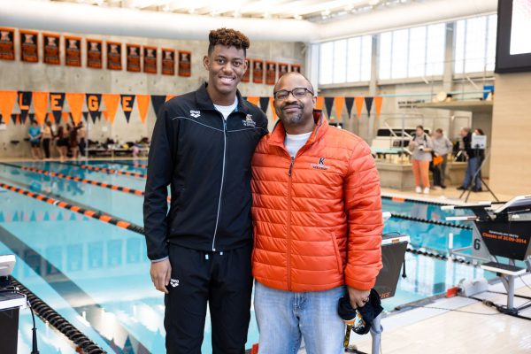 Swimmer Trustin Christopher posing with favorite professor Dwight Williams on the pool deck.
