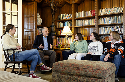 students chatting with their professor in a library