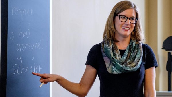 Tenure recipient Kathryn Sederberg pointing at a blackboard