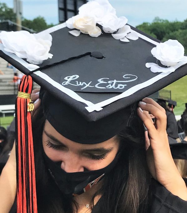 A female graduate wears a graduation cap that says Lux Esto during last year's commencement