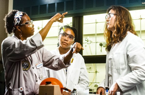 Regina Stevens-Truss Holds a Test Tube While Teaching Two Students for Science Society Award