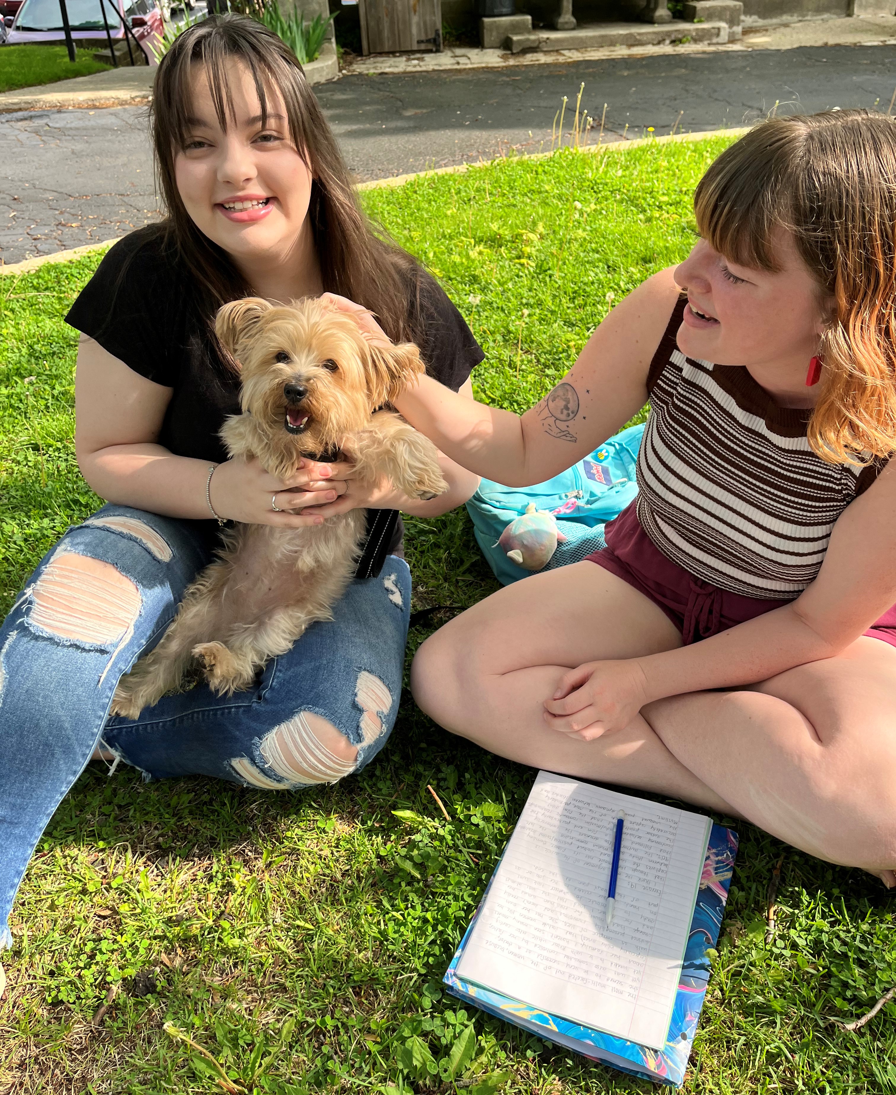 Two students with Yorkshire terrier Leia for International Dog Day