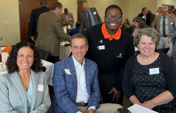 Four smiling community breakfast attendees