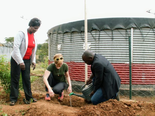 Sarah Fuhrman planting a tree with two others while performing humanitarian work in Kenya