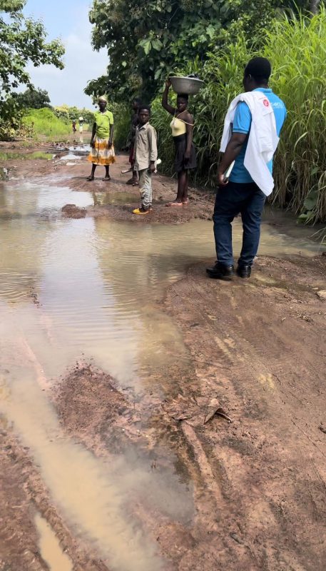 People walking down a flooded dirt road