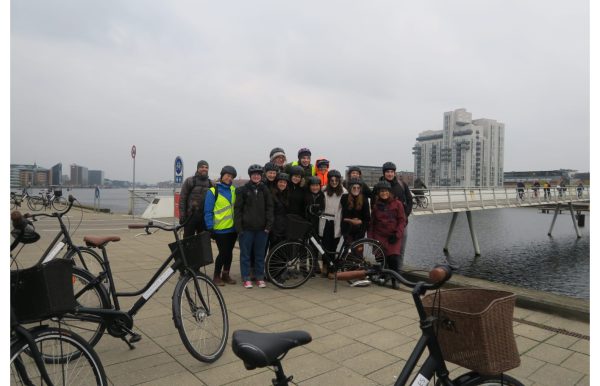 Students take a break from cycling to take a scenic group picture in Copenhagen