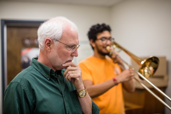 Jazz Band and Academy Street Winds Director Tom Evans with a trombone-playing student