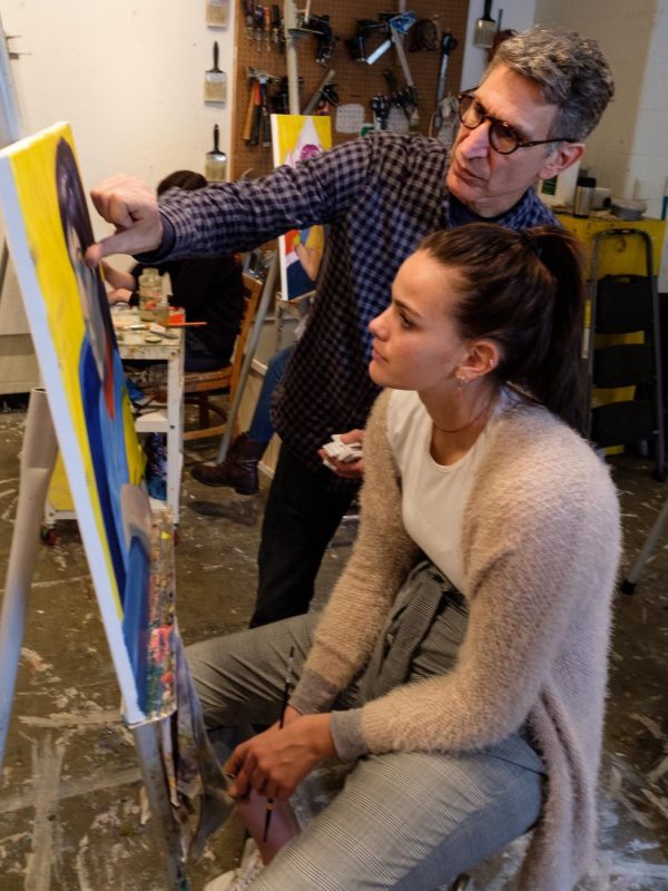 An art professor guides a student by pointing at her project best 389 colleges