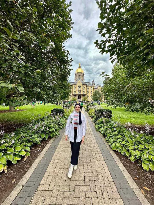 Visiting international student on a brick walkway in front of an ornate building