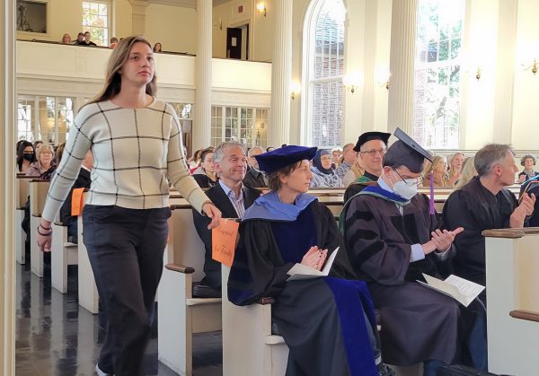 A student walks down an aisle at Stetson Chapel to receive her award on Honors Day 2023