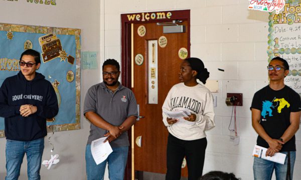 Four college students presenting in a classroom