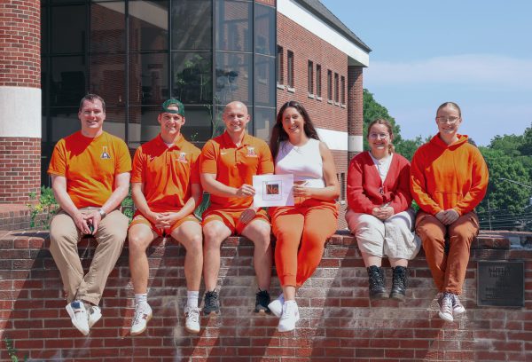 Five students with their professor on a sunny day outside Dow Science Center.