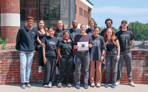 11 students with their professor on a sunny day outside Dow Science Center