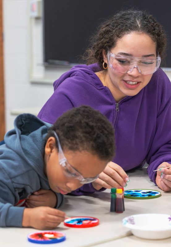 College student and child performing experiment