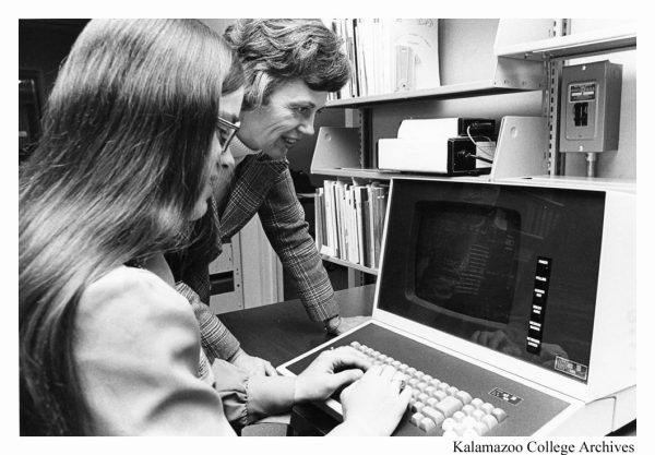 Eleanor Pinkham standing next to a computer while sharing how to use it with a student