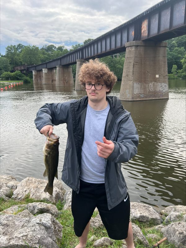 Student holding up a fish he caught near the Great Lakes