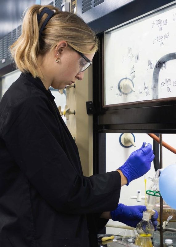 Olivia Cannizzaro working in the Williams lab under a fume hood.