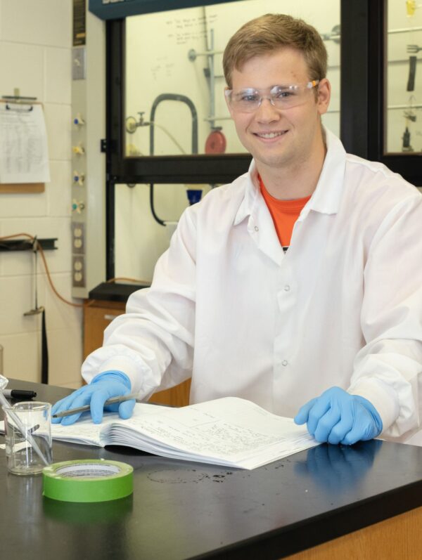 Student-athlete Logan Coller performs research in the chemistry lab of Blake Tresca
