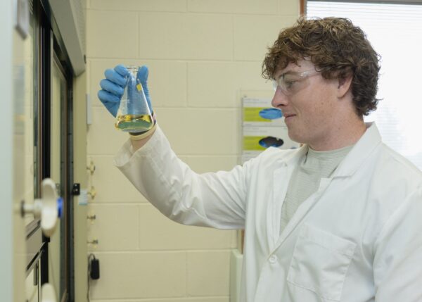Student-athlete Caleb Moore '27 performing research in the lab of Blake Tresca