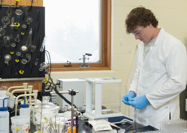 Student-athlete Caleb Moore performs summer research in the chemistry lab of Blake Tresca