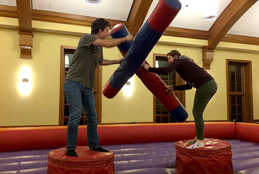 two K students playing on an inflatable gladiator game