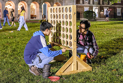 Two students playing life-sized connect four