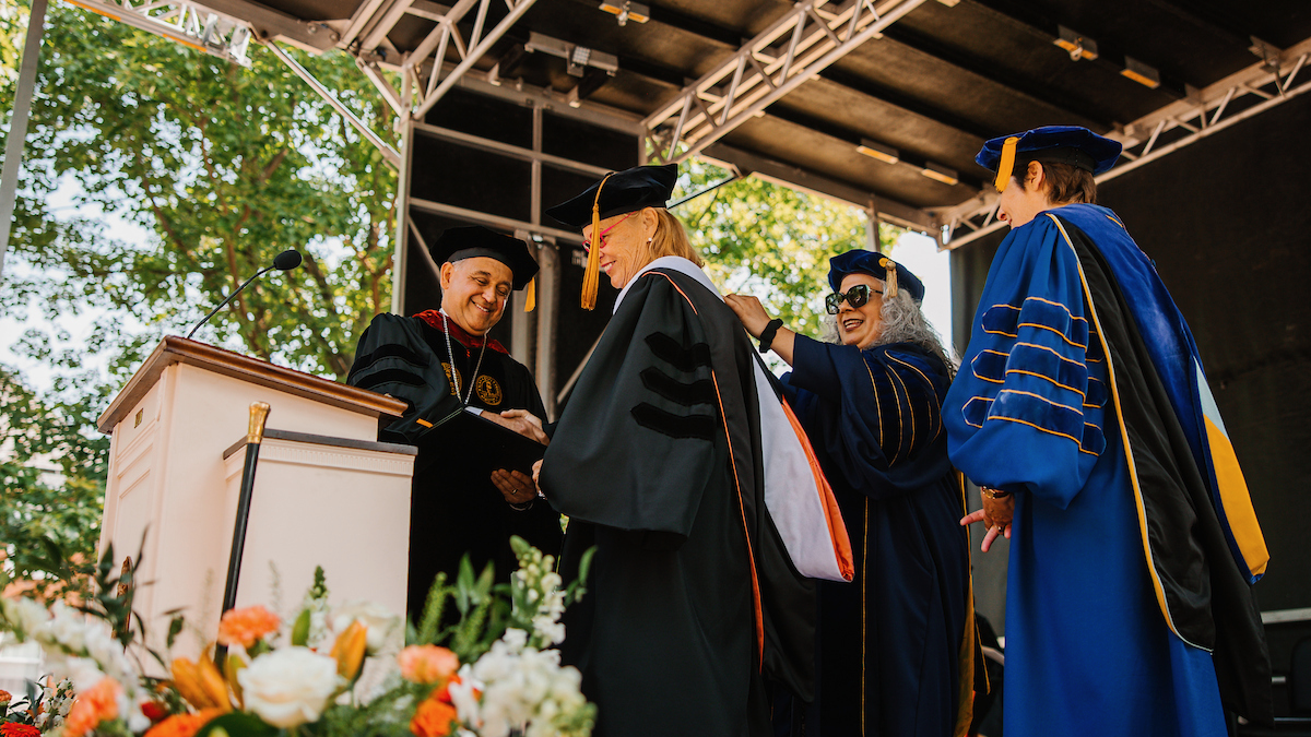 Ronda Stryker accepts honorary degree from president and faculty.