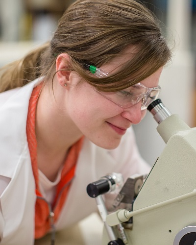 K student looking in a microscope