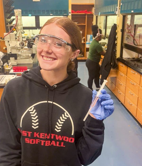 Landrie Fridsma, a student at Kalamazoo College, smiles while posing in a chemistry laboratory.