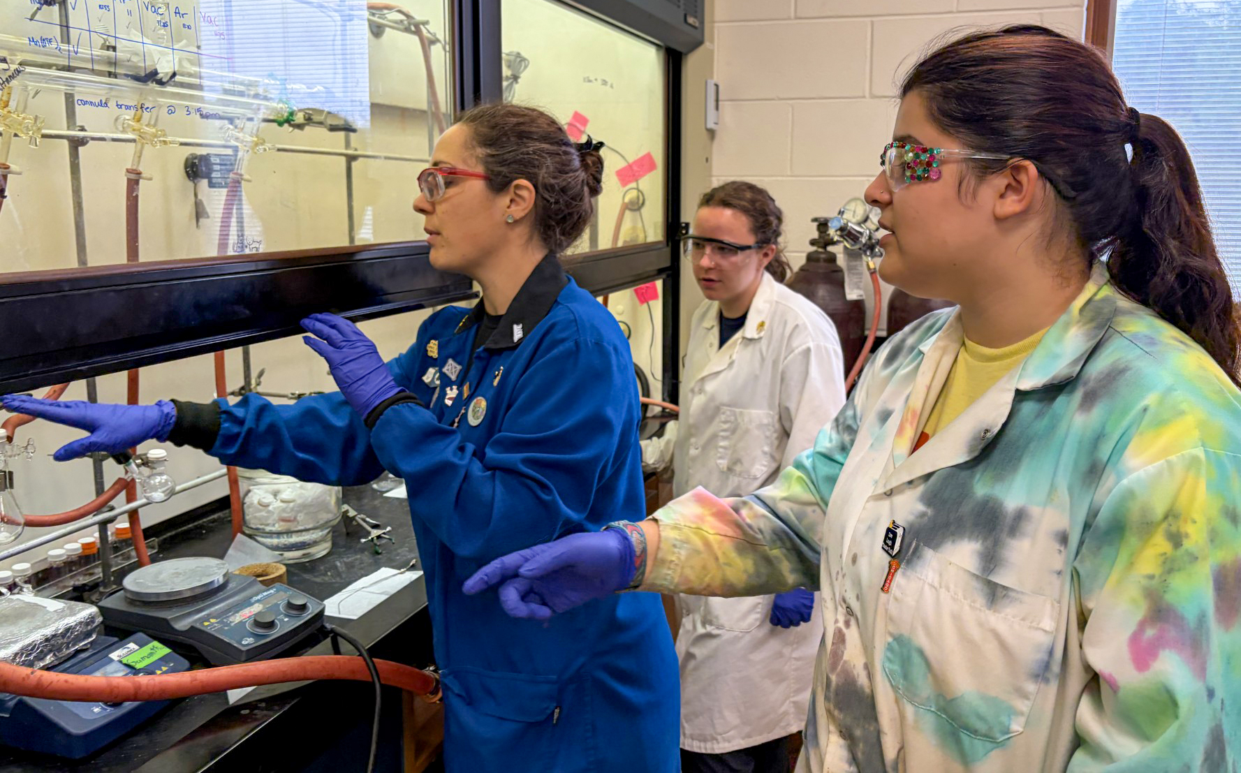 Dr. Daniela Arias-Rotondo, Caroline Johnson and Meena Moritz observing an experiment. 