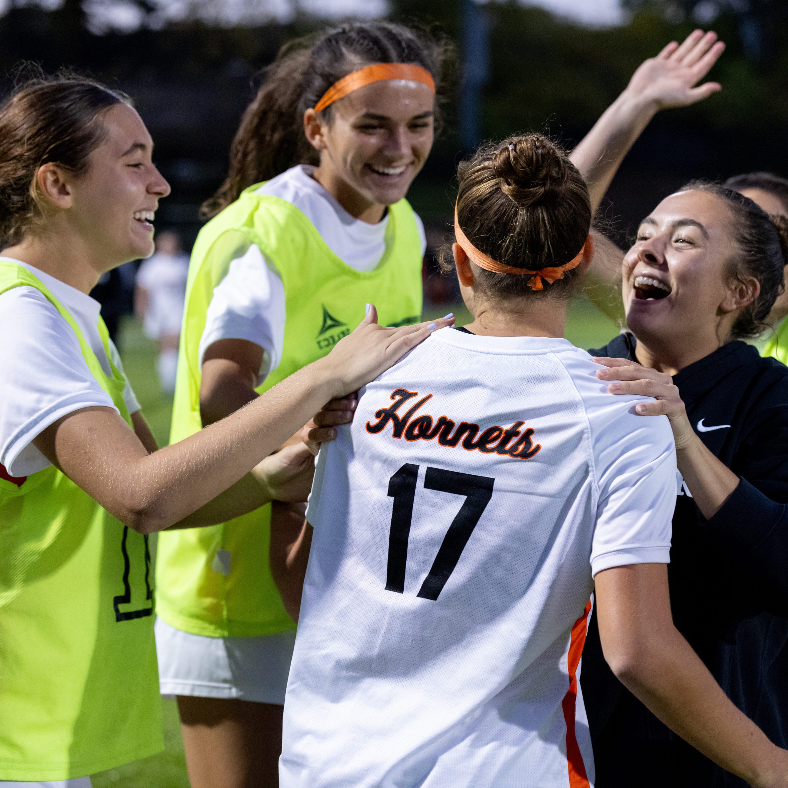 Members of the women's soccer team celebrate a team goal.