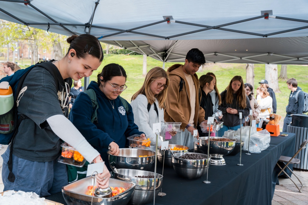 Students at buffet scooping snacks out of metal bowls. 