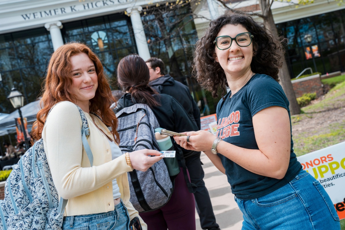 Two students in line in front of Weimer K. Hicks Student Center. 