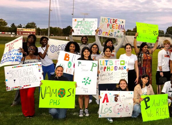 Kalamazoo Language and Intercultural Partners Program at a soccer game holding signs. 