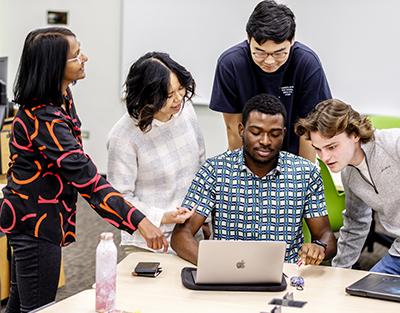 A professor working with students in the classroom