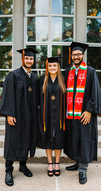 three students in their graduation gowns