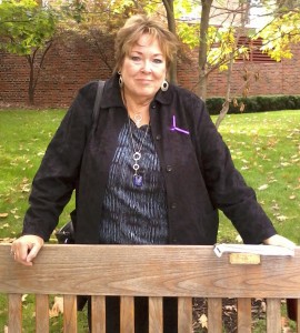 Gail Griffin stands next to “Maggie’s Bench” next to Stetson Chapel