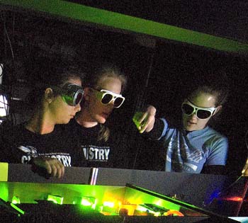 Three chemistry students wearing goggles in the laser lab at K