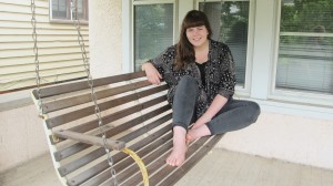 Haley Cartwright sits outside on a swinging bench