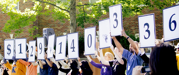Participants in the Campaign for Kalamazoo College hold up signs indicating $129,140,336 was raised