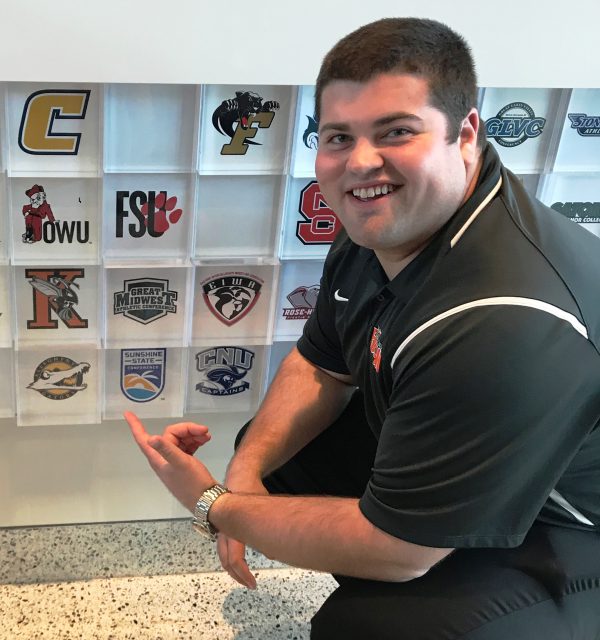 Future College Coach Brad Bez Squatting Next to Logos