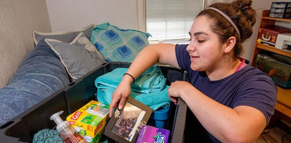 Mattie Del Torro Grabs a Photo from a Crate for What to Bring to Campus Story