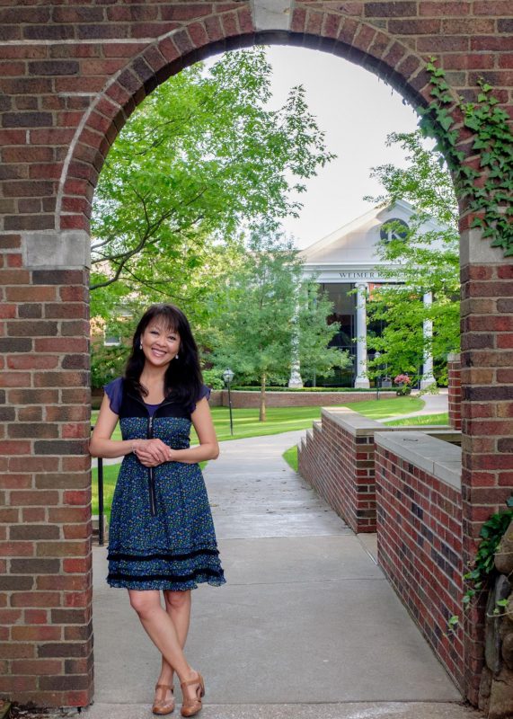 Siu-Lan Tan, one of five endowed chairs, stands under the Quad archway