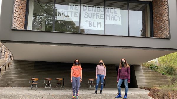 Three students who had International Internships standing in front of the Arcus Center for Social Justice Leadership